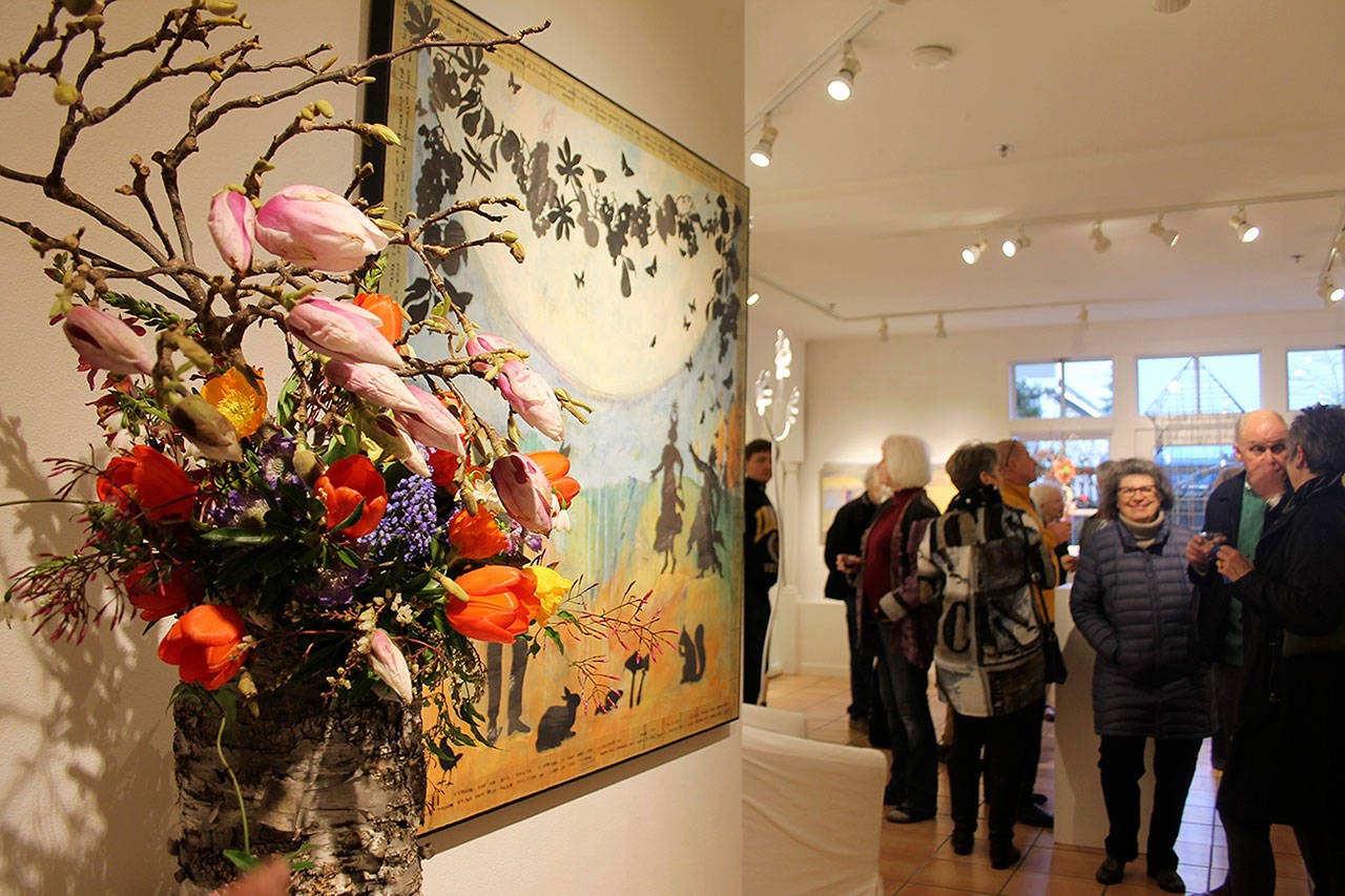 Kyle Jensen / The Record — Gallery visitors observe Melissa Koch’s “Stella — Luna,” paired with an arrangement made by Sonshine Flower Farm’s Pam and Kelly Uhlig.