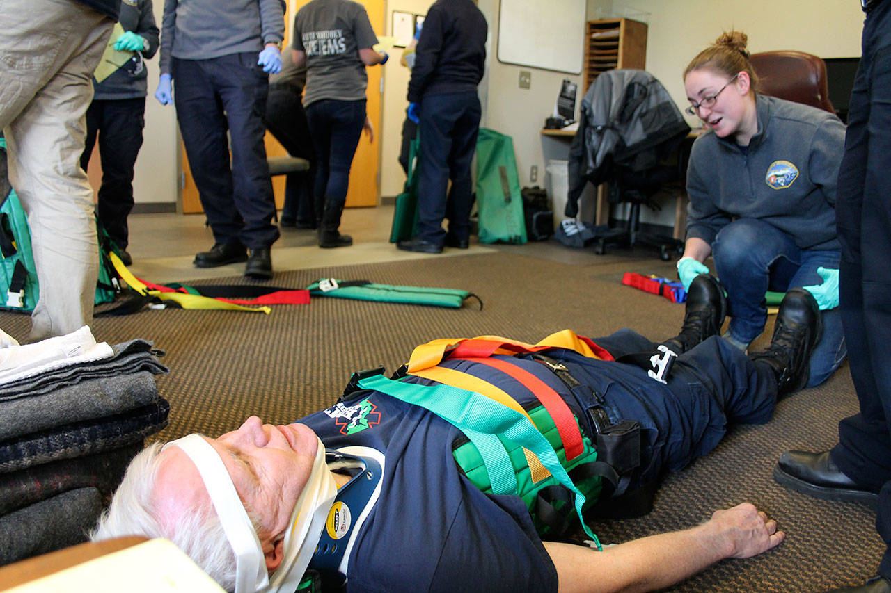 Kyle Jensen / The Record — Volunteer firefighter and EMT Ken Starkweather plays patient as trainee Carlee Mills practices trauma patient assessment.