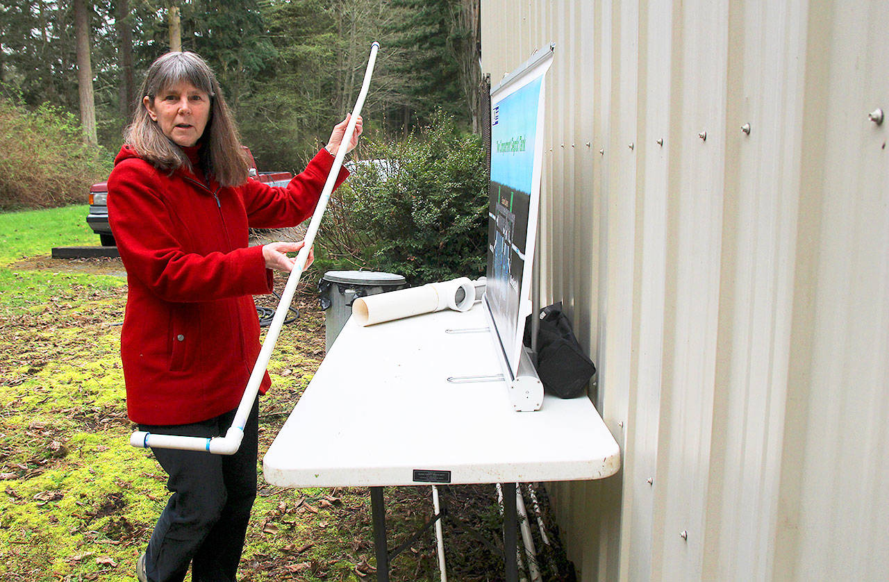 Island County environmental health educator Maribeth Crandell demonstrates a sludge stick used to measure accumulation in a septic tank. Photo by Patricia Guthrie/Whidbey News-Times