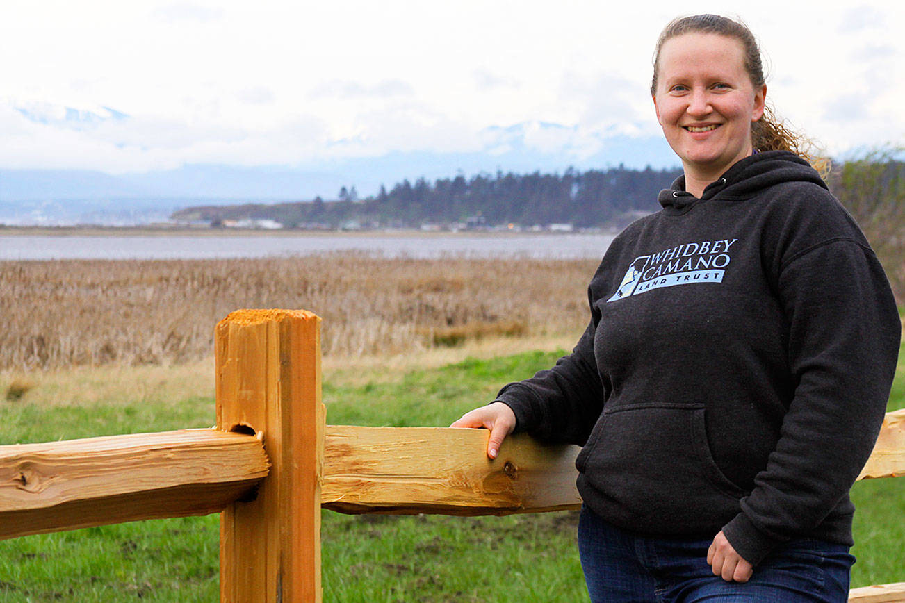 Jessica Larson, a land steward with the Whidbey Camano Land Trust, stands before a split-rail fence Thursday, Aprl 6, 2018 that was installed in March to keep duck hunters and others from parking on the property near Crockett Lake in Central Whidbey. The land trust purchased the 85-acre property from a private landowner in December on the lake’s northeast corner to protect it and its abundant species of birds as part of the 423-acre Crockett Lake Wetland Preserve. The newly acquired property had been a widely used access point and place to park for waterfowl hunters for years. Photo by Ron Newberry/Whidbey News-Times