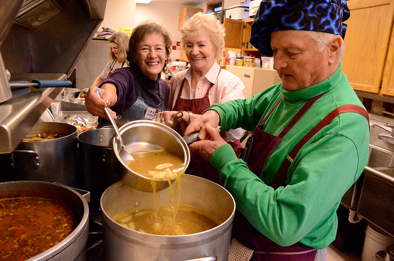 Record file — Sharon Giberson and Jean Matheny help Dan Saul mix soup early on a Tuesday morning in preparation for the day’s lunch. Saul is leaving the soup kitchen after 14 years.