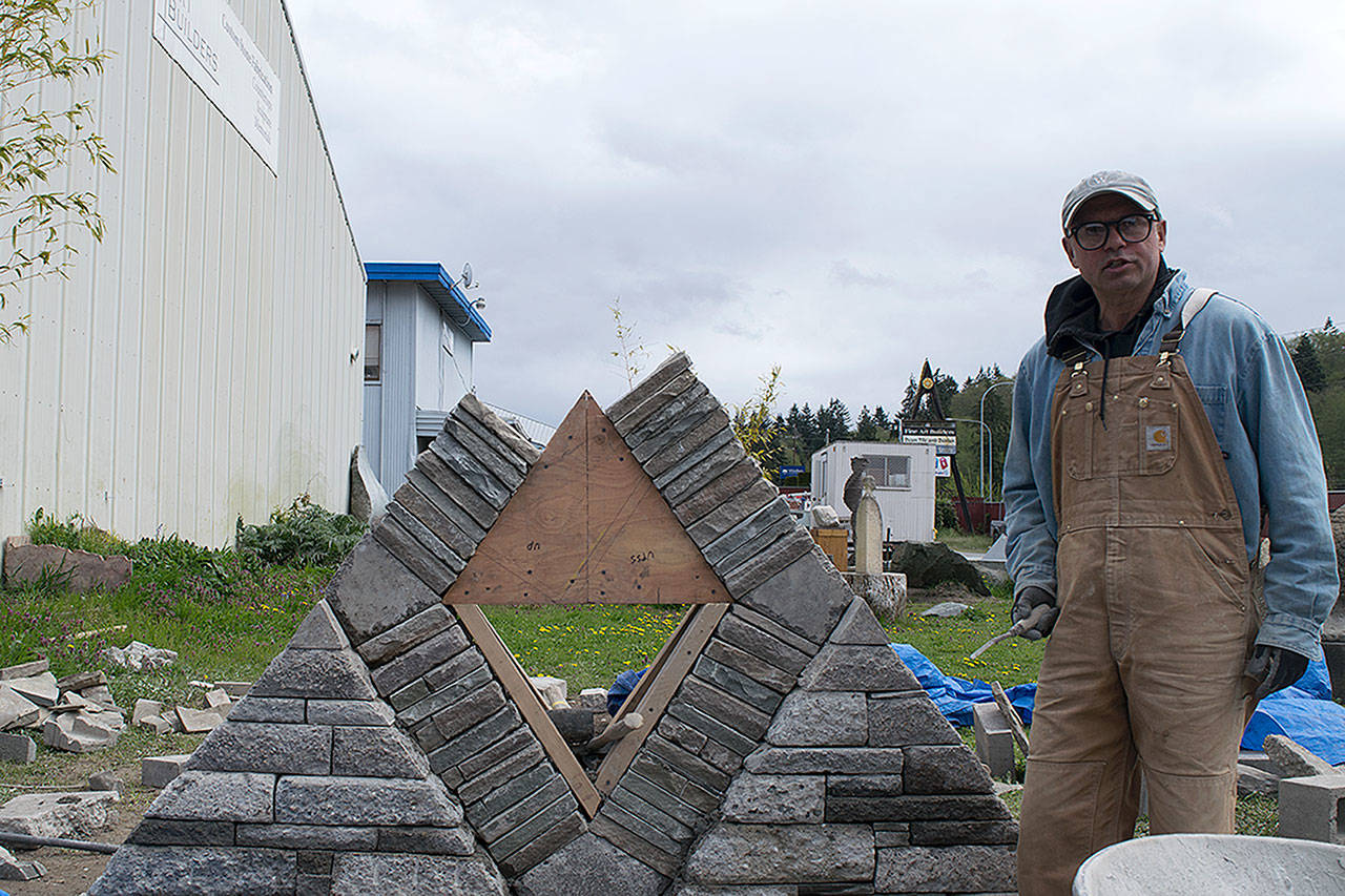 Kyle Jensen / The Record — Featured sculptor Hector Santos works toward completing his piece “Urban Pyramid” before the opening of the sculpture garden on Saturday.