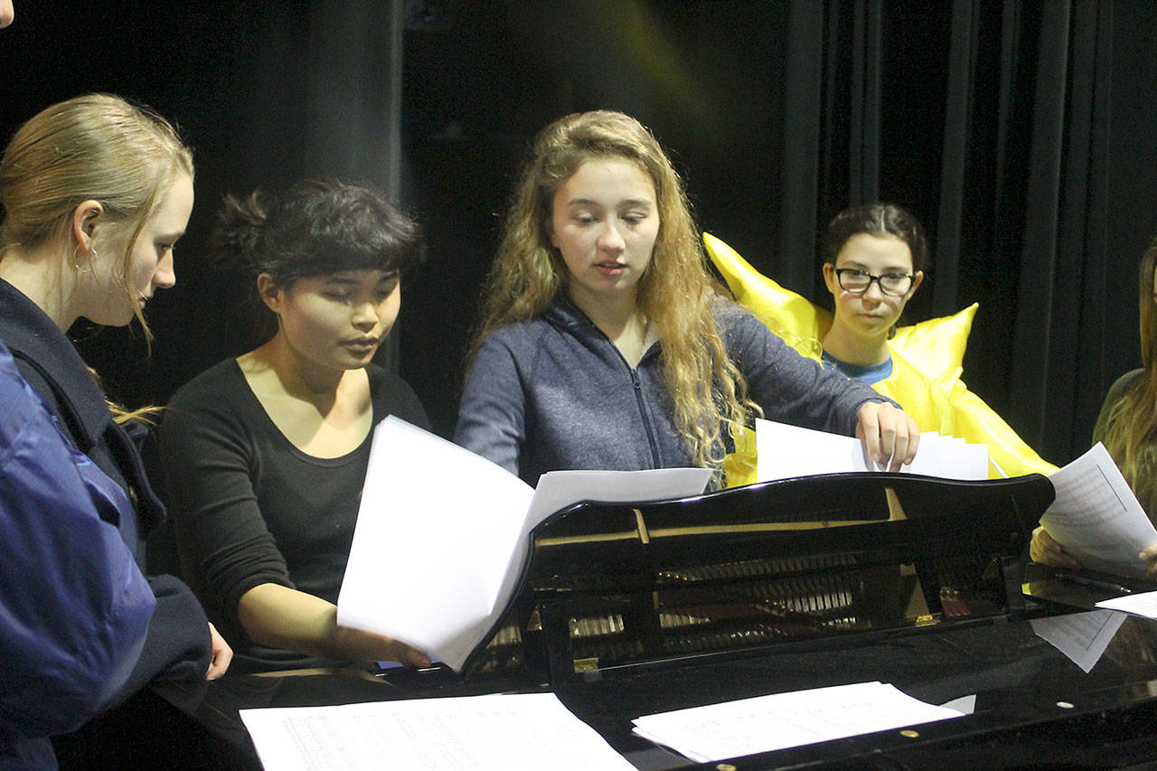 Evan Thompson / The Record &mdash; Kari Hustad, center, goes over the lyrics with other members of the Climate Arts Project at a rehearsal on Monday afternoon. From left to right: Chloe Hood, Katyrose Jordan, Hustad and Marla Kelly.