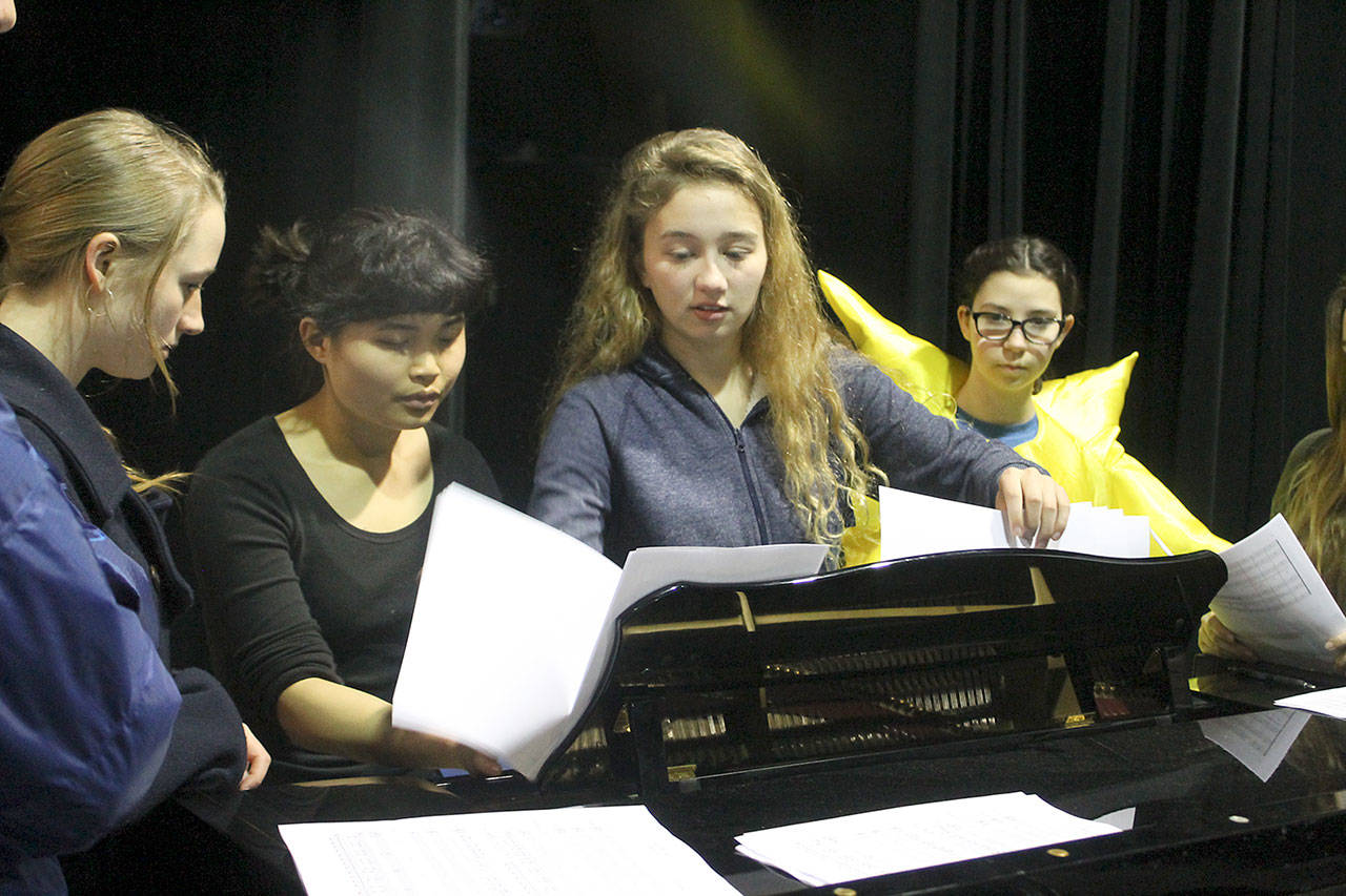 Evan Thompson / The Record — Kari Hustad, center, goes over the lyrics with other members of the Climate Arts Project at a rehearsal on Monday afternoon. From left to right: Chloe Hood, Katyrose Jordan, Hustad and Marla Kelly.