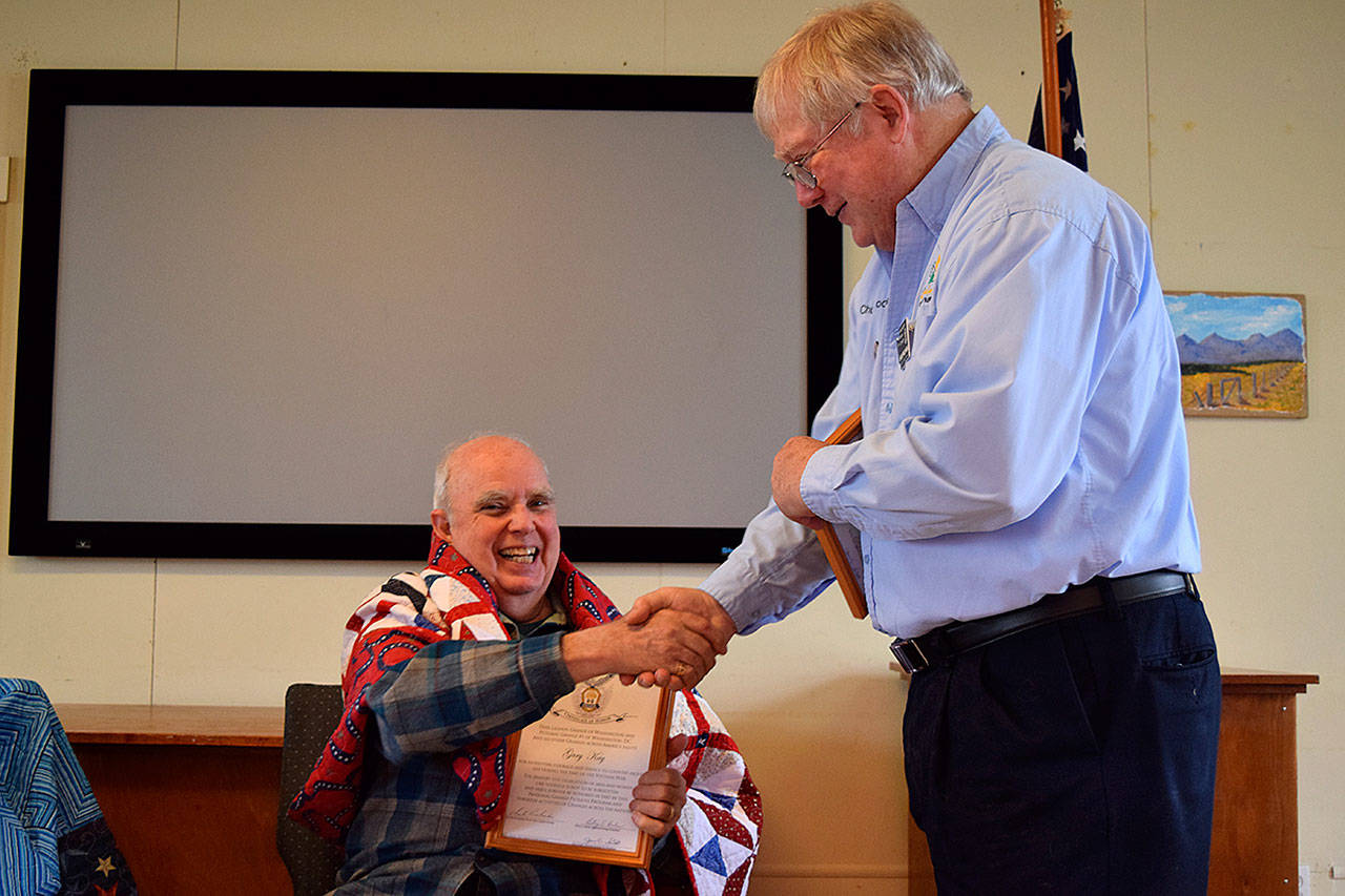 Kyle Jensen / The Record &mdash; Deer Lagoon Grange Master Chuck Prochaska presents an award to United States Navy veteran Gary Kay after Anita Smith presented him with a quilt made from her volunteer group.