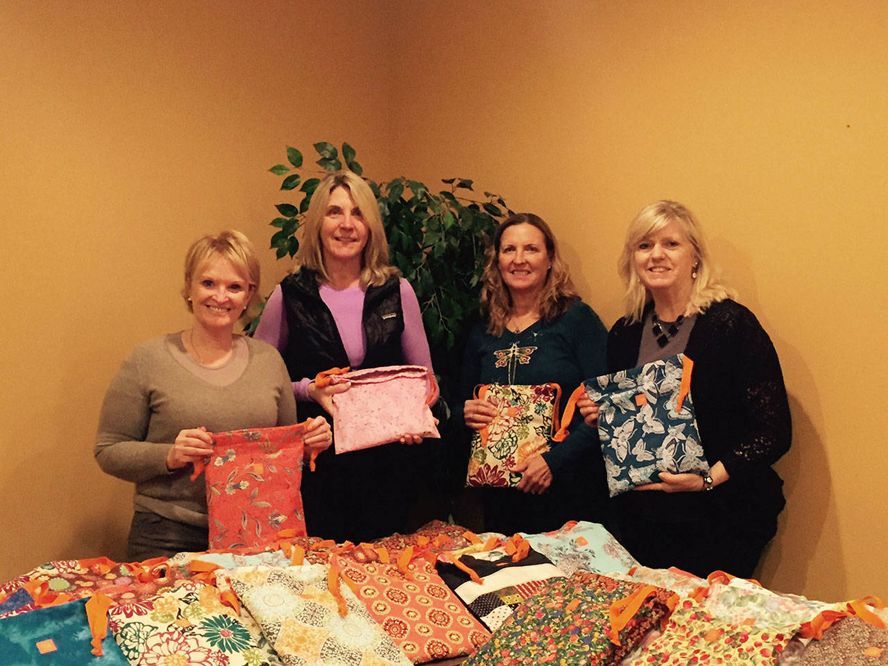 Conrtibuted photo — Days for Girls South Whidbey sews kits bound for girls all over the world. Left to right, Janette Skaardal, Michele Bolvin, Cindi Bowen and Traci Winn display some of the 100 kits taken by Freeland Trinity Lutheran Church to Haiti.