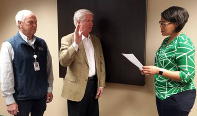 Kurt S. Blakenship is sworn in as District 2 Commissioner for Whidbey Island Public Health District by Lorrie Mendik, WhidbeyHealth employee. Board president Ron Wallin looks on. Photo provided.