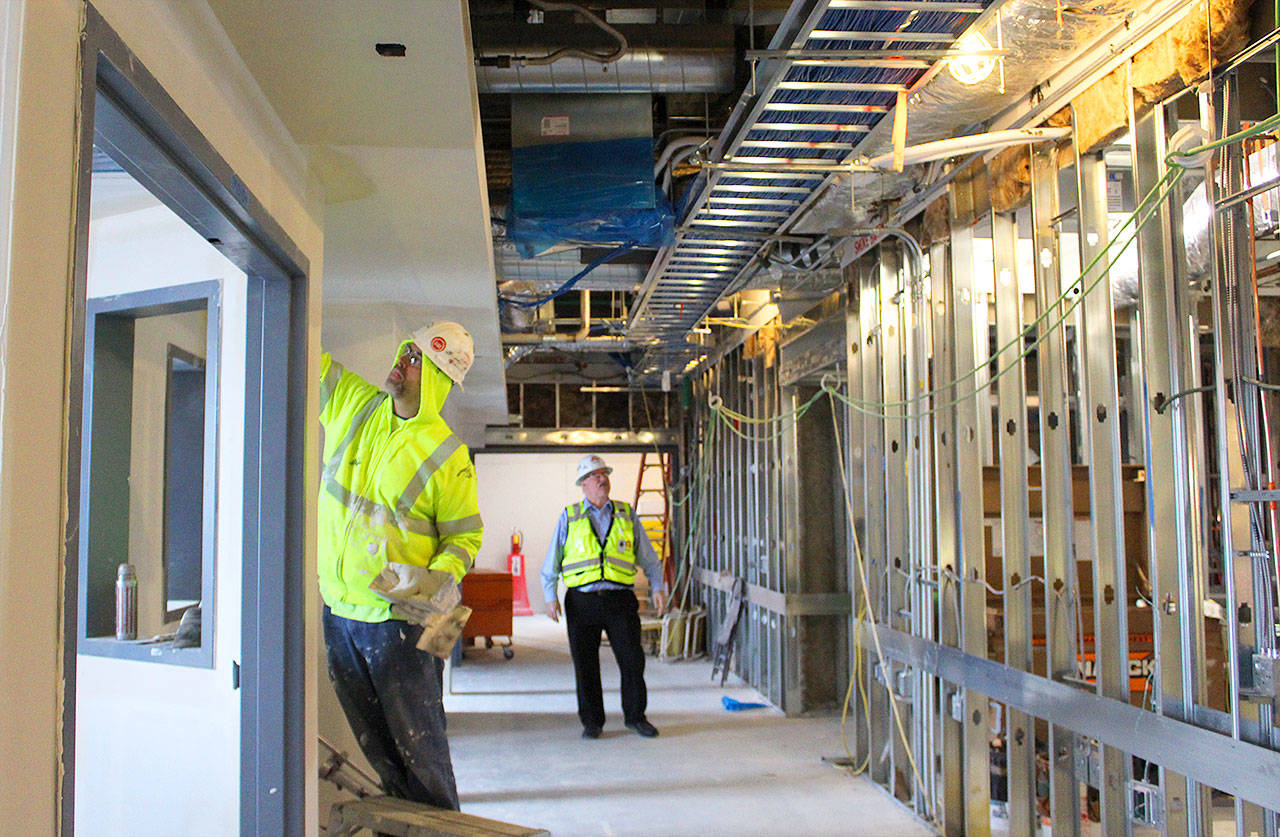 Patricia Guthrie / Whidbey News-Times — George Senerth (right) WhidbeyHealth executive director of facilities, checks on construction progress of the new addition. Its innovative heating and cooling system is predicted to reduce energy use by half.