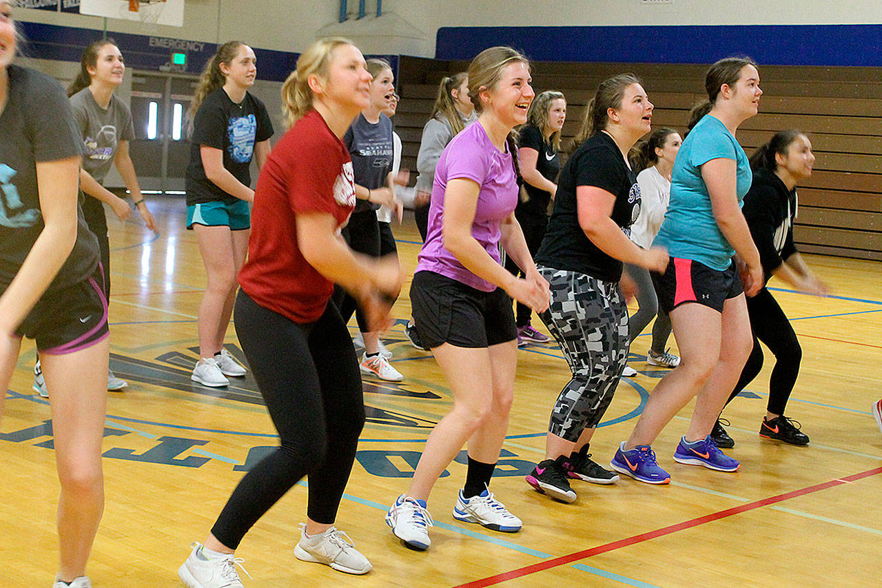 Evan Thompson / The Record — South Whidbey girls tennis players spent part of Monday’s practice inside loosening up to the rhythm dance game “Just Dance” for 30 minutes due to rainwater on the courts.