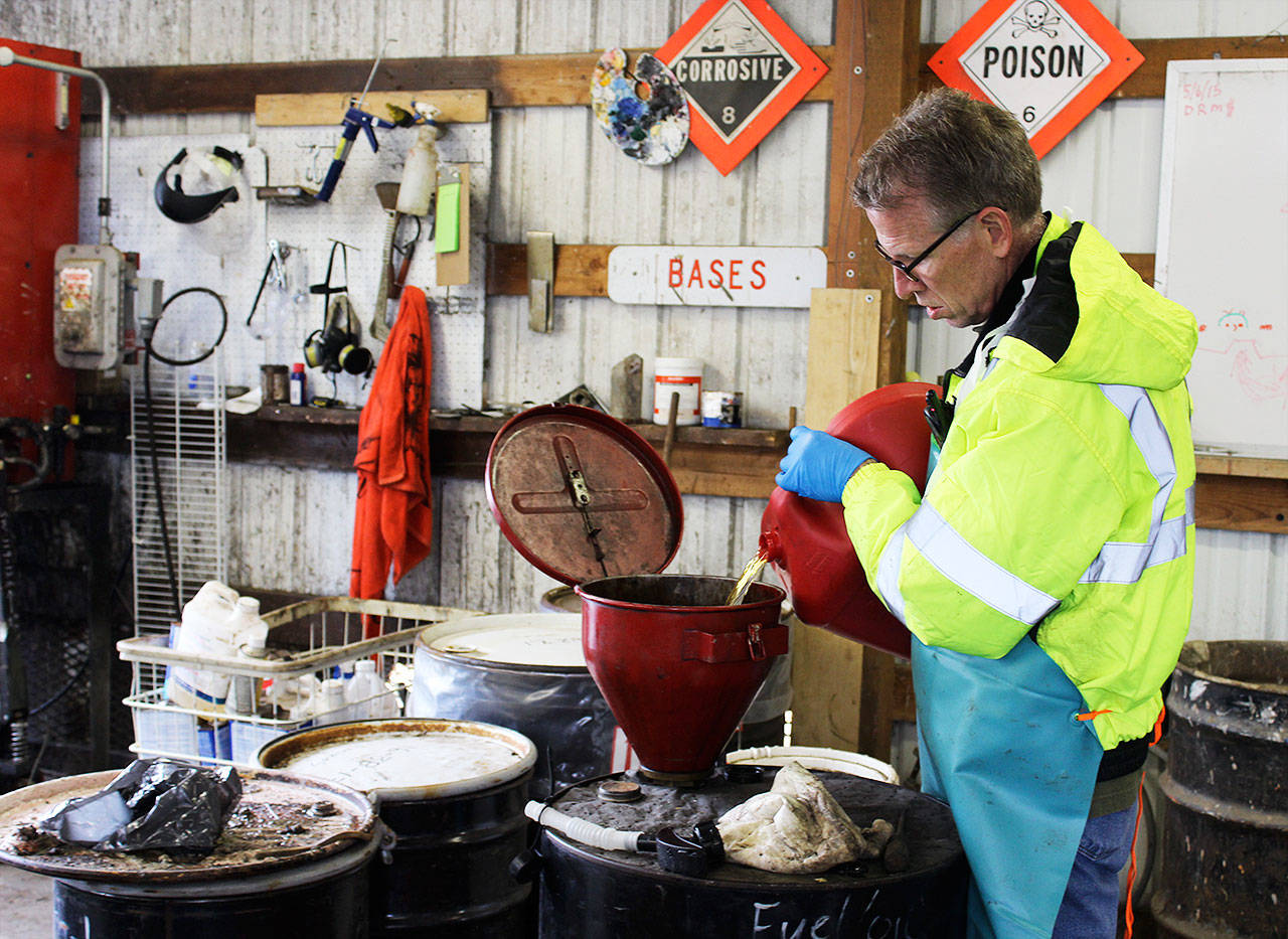 Almost 90 gallons of gas that had sat on a boat for eight years is handled by John Vance who handles household hazardous waste at the Coupeville Solid Waste Complex. Photo by Patricia Guthrie/Whidbey News-Times