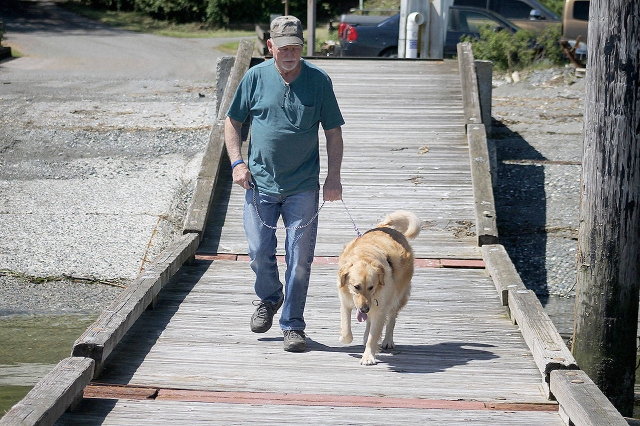 Evan Thompson / The Record &mdash; Perry Mitchell, a Coupeville resident, walks his dog named Brandy down the float dock at Possession Beach Waterfront Park.