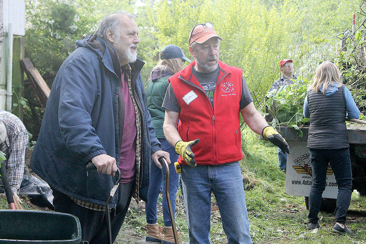 Evan Thompson / The Record — Rick Emlee, left, speaks with Hearts & Hammers work party team captain Clayton Granby during the non-profit organization’s 24th annual workday on Saturday morning.