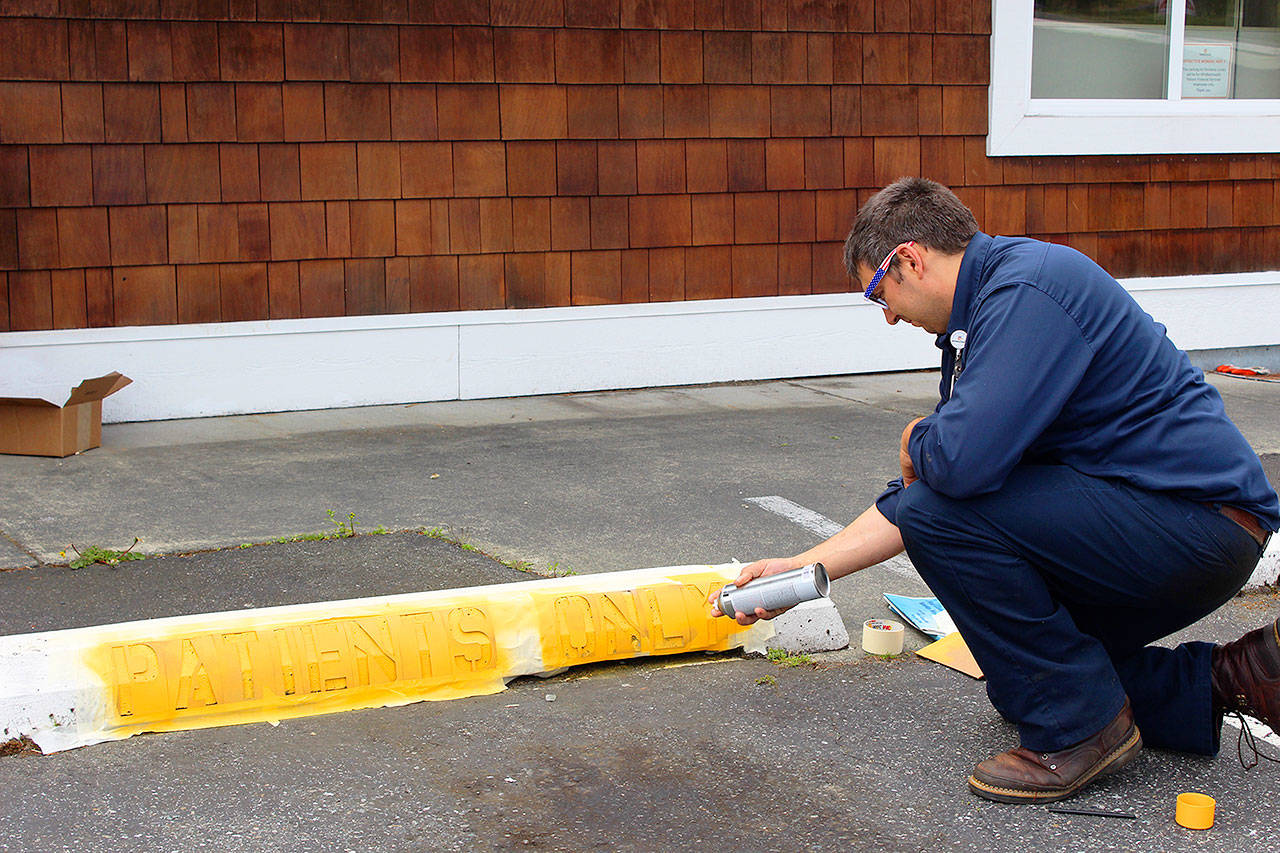 Justin Green works on the parking lot of WhidbeyHealth Patient Financial Services, which consolidated offices over the weekend. The building, once Linds Pharmacy, is located at 40 N. Main Street in Coupeville. Photo by Patricia Guthrie/Whidbey News-Times