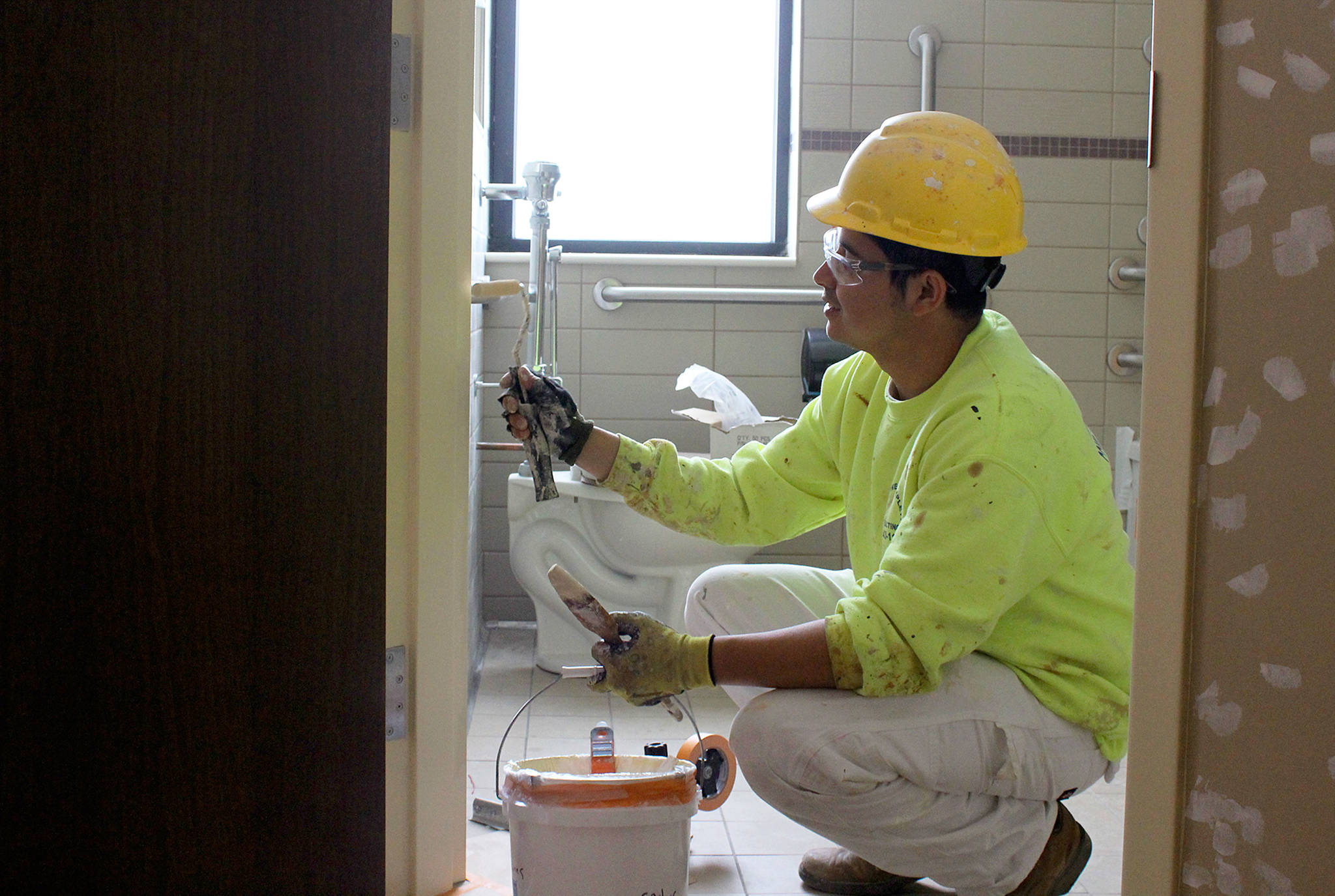 Patricia Guthrie/Whidbey News-Times &mdash; Working on the finishing touches of a patient room inside the new wing of WhidbeyHealth Medical Center, Carlos Torres paints a bathroom door. The 39-bed addition is slated to open July 7.