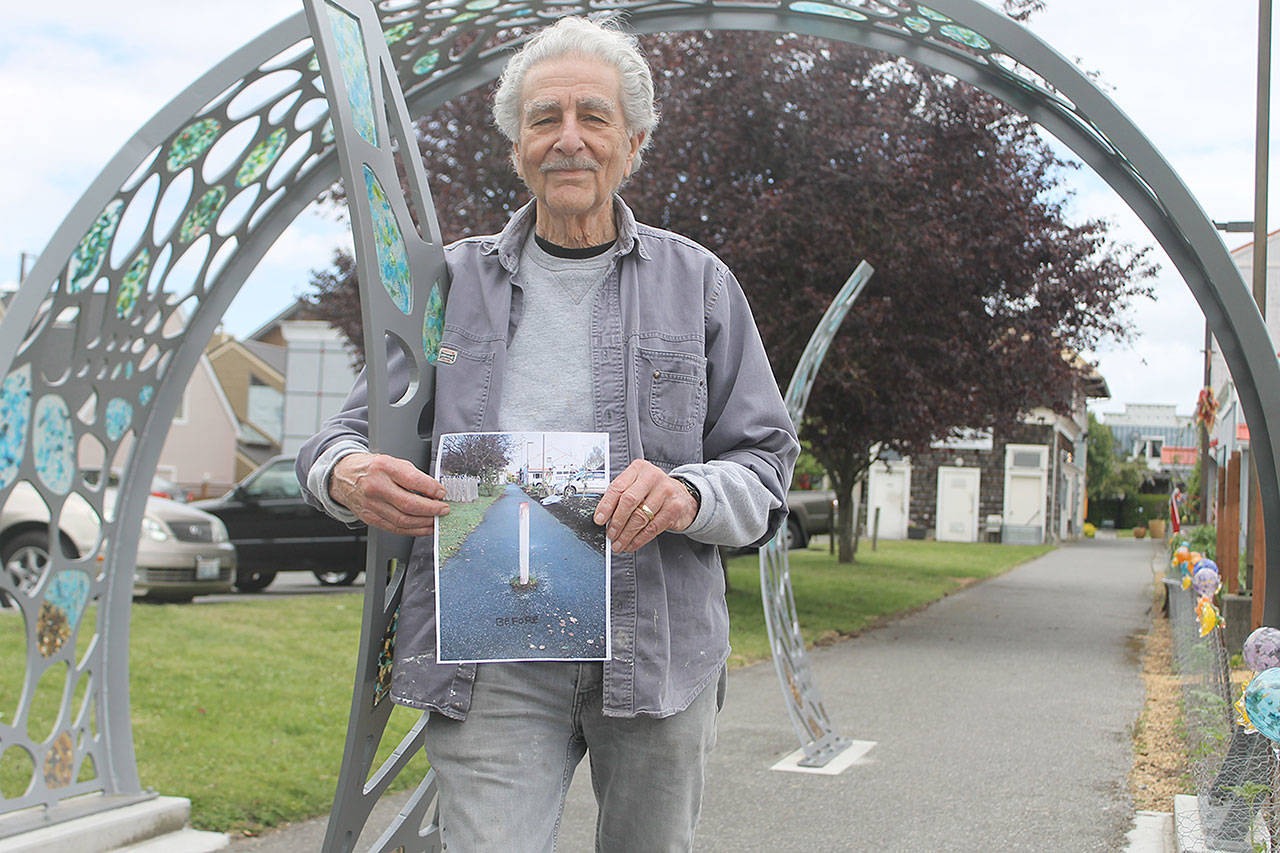 Evan Thompson / The Record — Frank Rose, chairman of the Langley Arts Commission, holds a picture of what Clyde Alley looked like before it received an artistic facelift. More art is on the way for the connecting alley between Second Street and Third Street.