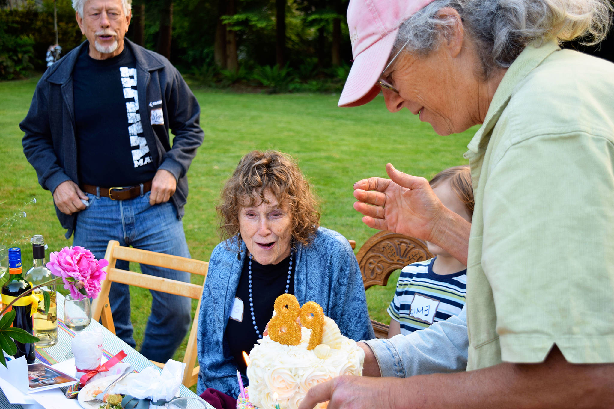 Cary Peterson (right) presents her mother, Meg Noble Peterson, with a birthday cake Saturday at a Langley neighborhoodpicnic. Peterson, who just turned 89, is representative of Whidbey Island’s ranking as a leader in longevity. Photos by Patricia Guthrie/South Whidbey Record