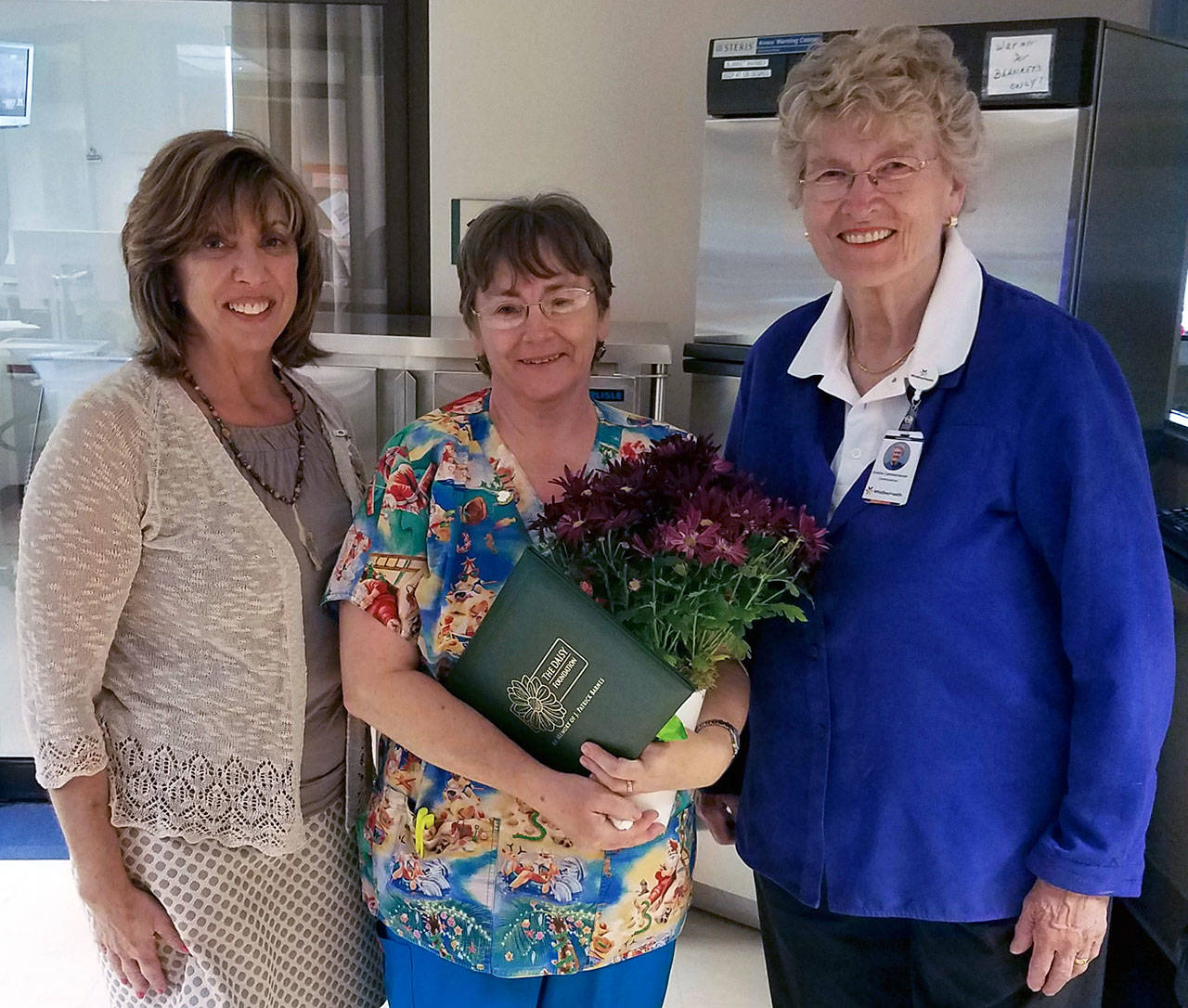 Contributed image — DAISY Award recipient Ellen Giles, RN (center) is congratulated by WhidbeyHealth CEO Geri Forbes (left) and Hospital District 1 Commissioner Grethe Cammermeyer on May 12 .