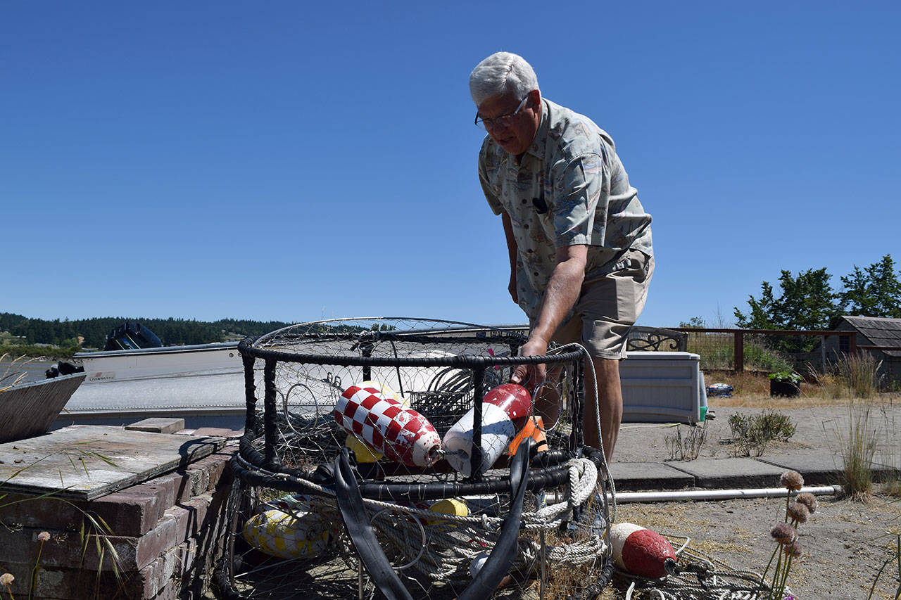 Kyle Jensen / The Record — Sunlight Beach resident Cliff Slade brings out his commercial traps from his backyard. Slade has been crabbing in Useless Bay for 60 years.