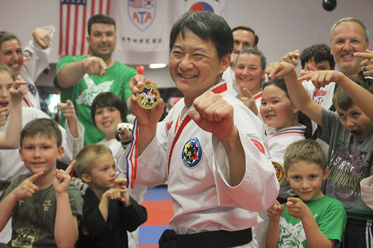 Evan Thompson / The Record — Jeffrey Chia won the sparring title at the American Taekwondo Association World Championships on June 25 in Little Rock, Ark. Students and instructors at Armstrong’s Taekwondo congratulated him at the mixed martial arts school on Monday afternoon.