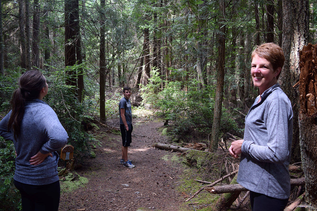 Kyle Jensen / The Record — Shelley Ackerman (right) is leading a grassroots effort to purchase land behind the old South Whidbey primary school that contain trails. Also pictured: Sydney Ackerman (left) and Corey Ackerman (center).
