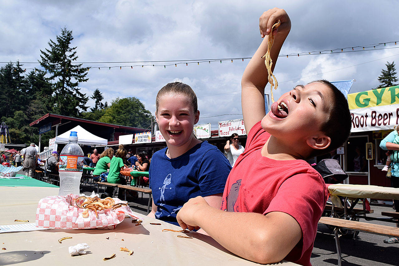 Kyle Jensen / The Record — Freeland residents Miles and Sophie Price chow down on curly fries during the opening day of the 2017 Whidbey Island Fair.