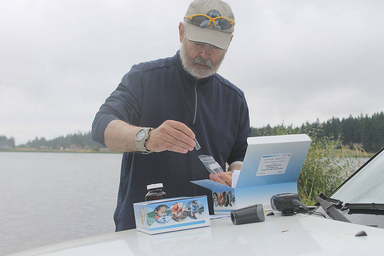 Evan Thompson / The Record — Clyde Jenkins of the South Whidbey Yacht Club collected water samples from Lone Lake on Thursday morning. The samples are being sent to King County for further analysis.