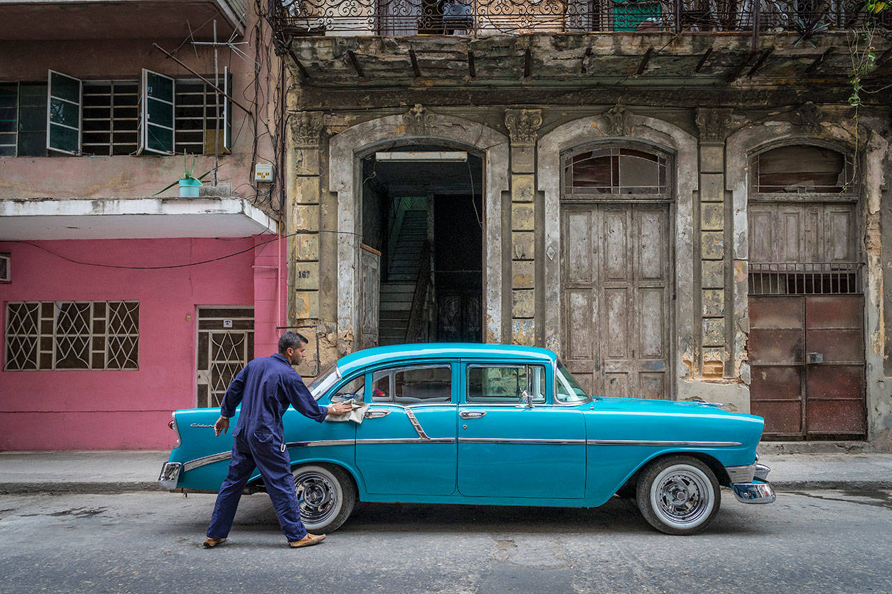 Marie Plakos photo &mdash; Marie Plakos captured a man rigorously cleaning his 1950&rsquo;s Chevy. Maintaining retro American cars is an iconic sight in Cuba.