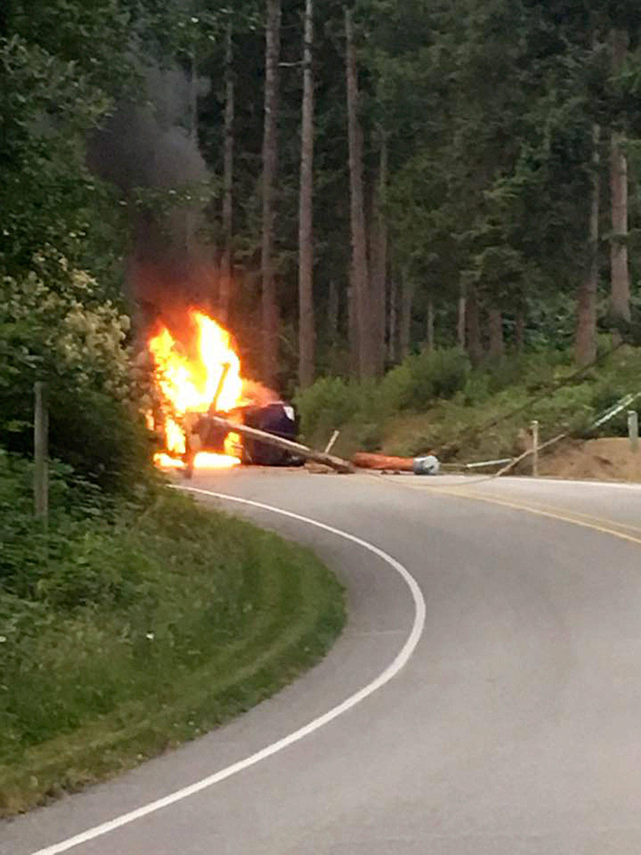 Contributed photo &mdash; A black sedan caught fire after colliding with a power pole on Bailey Road Monday morning. The driver escaped without injuries.