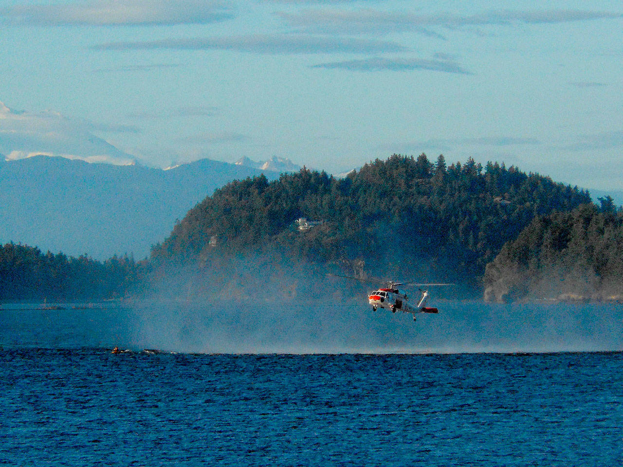 A SAR helicopter from Whidbey Island Naval Air Station rescues a distressed kayaker in Dugualla Bay Monday night. Photo by Richard Haines