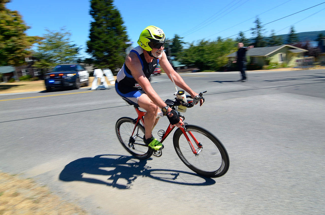 Justin Burnett / The Record — Pat Hogan of Gig Harbor whips around a corner in Langley during the Whidbey Triathlon on Saturday. He did the race with his wife, Joan Hogan.
