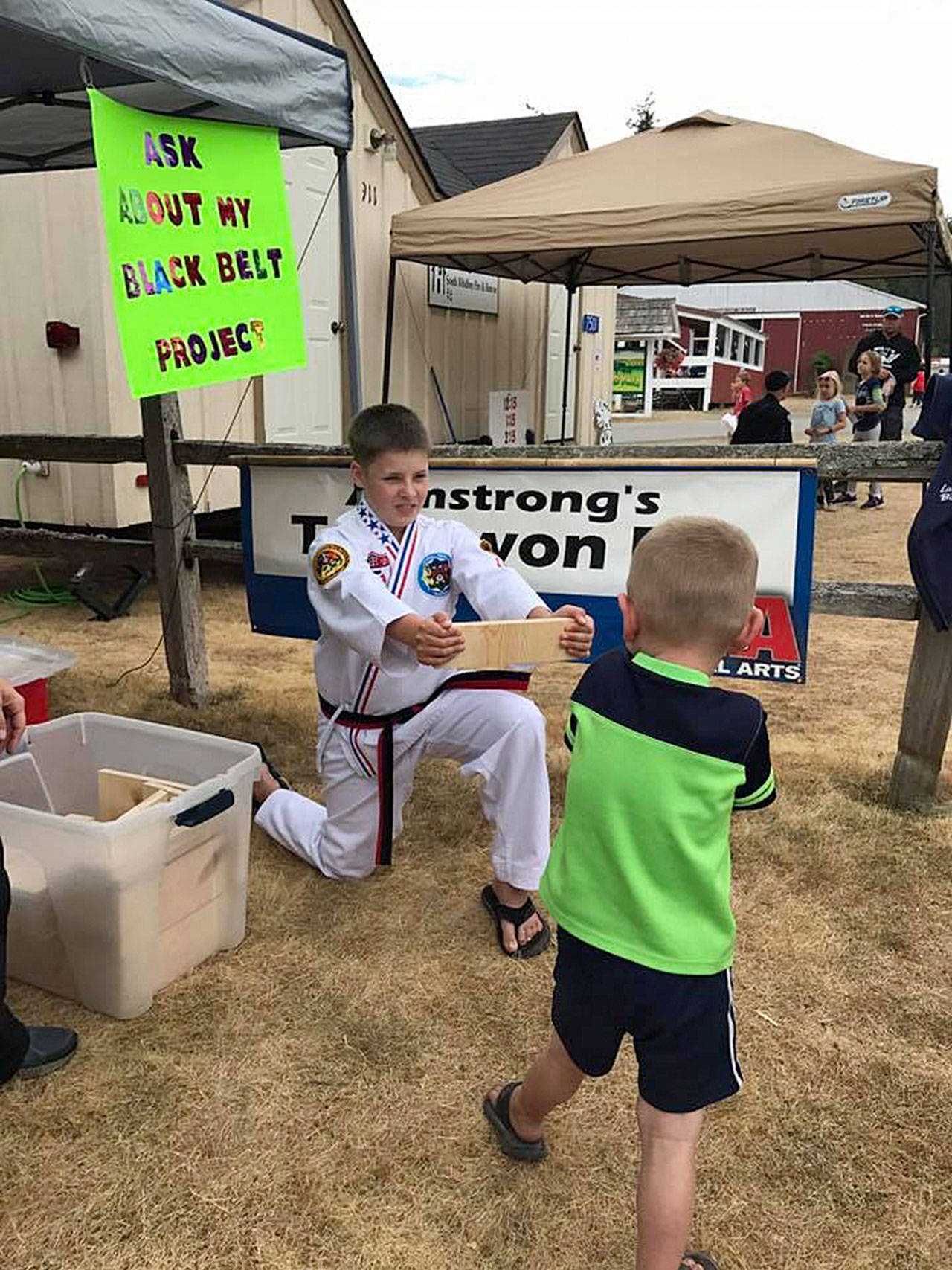 Contributed photo &mdash; Freeland resident Nicholas Armstrong holds a wooden board for someone to break at the Whidbey Island Fair.