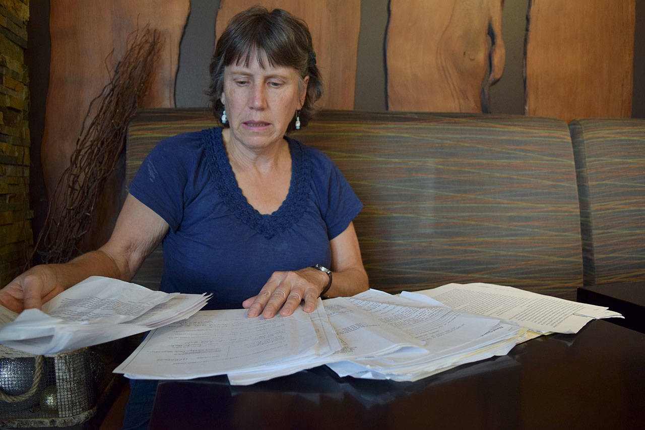 Kyle Jensen / The Record — Freeland resident Carolyn Buck sifts through a large file of paperwork acquired while attempting to obtain guardianship of her disabled sister.