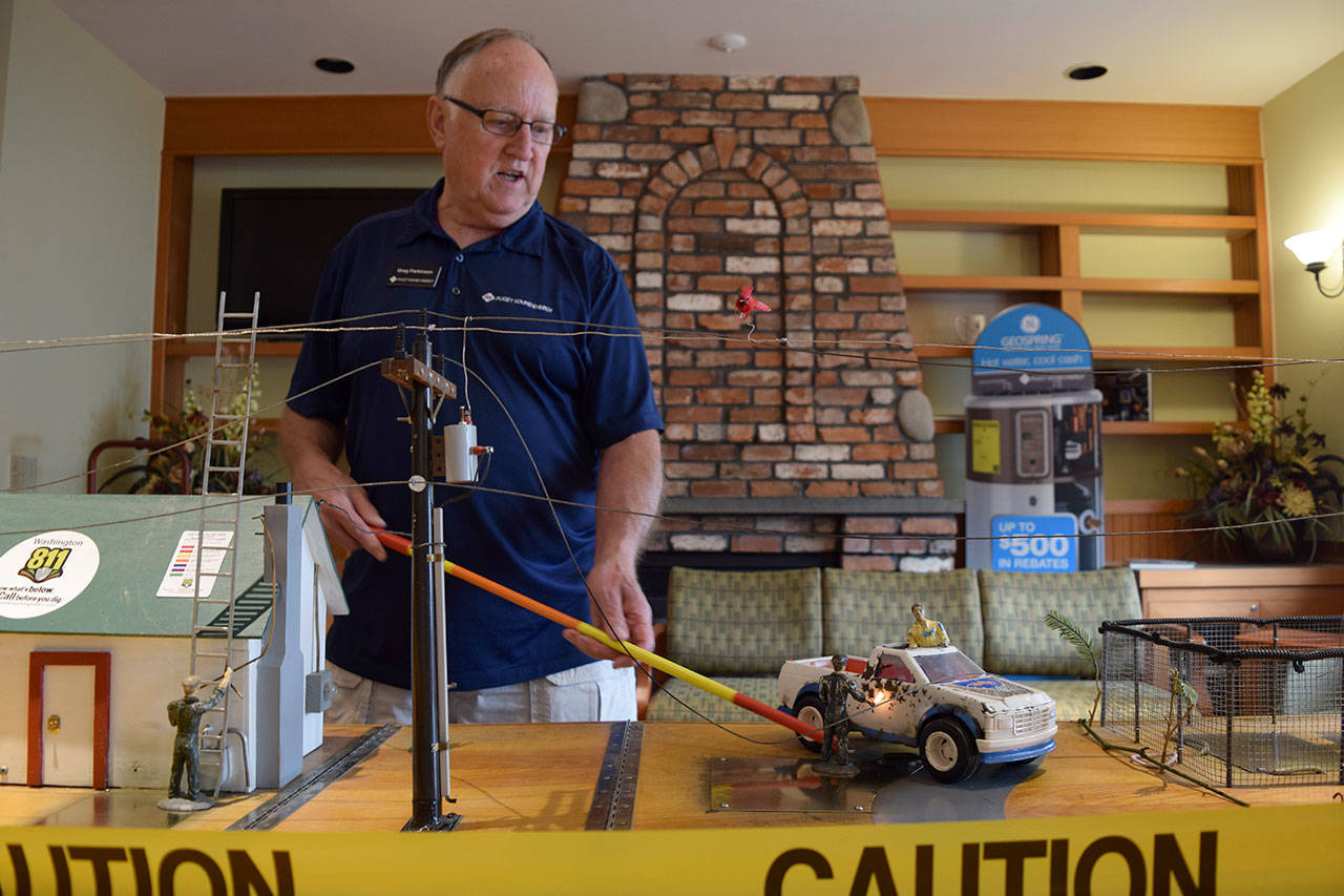 Kyle Jensen / The Record &mdash; Greg Parkinson demonstrates when downed power lines could potentially electrocute someone.