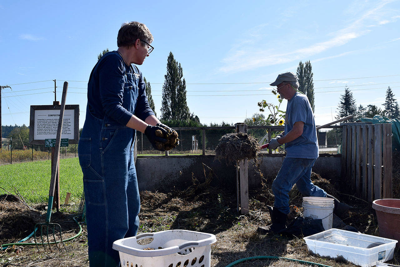 Kyle Jensen / The Record — Washington State University Master Gardener Tom Vincent, right, leads a group through the process of make a hot compost pile. Hot compost takes one month to create, as opposed to the 12 months regular compost takes.