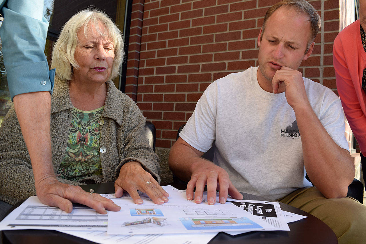 Kyle Jensen / The Record &mdash; THINC board members Maralie Johnson and Adam Breedlove glance over the blueprint for the 220-square-foot tiny houses. The nonprofit aims to purchase land to build at least six tiny houses as a way to add more affordable housing to South Whidbey.