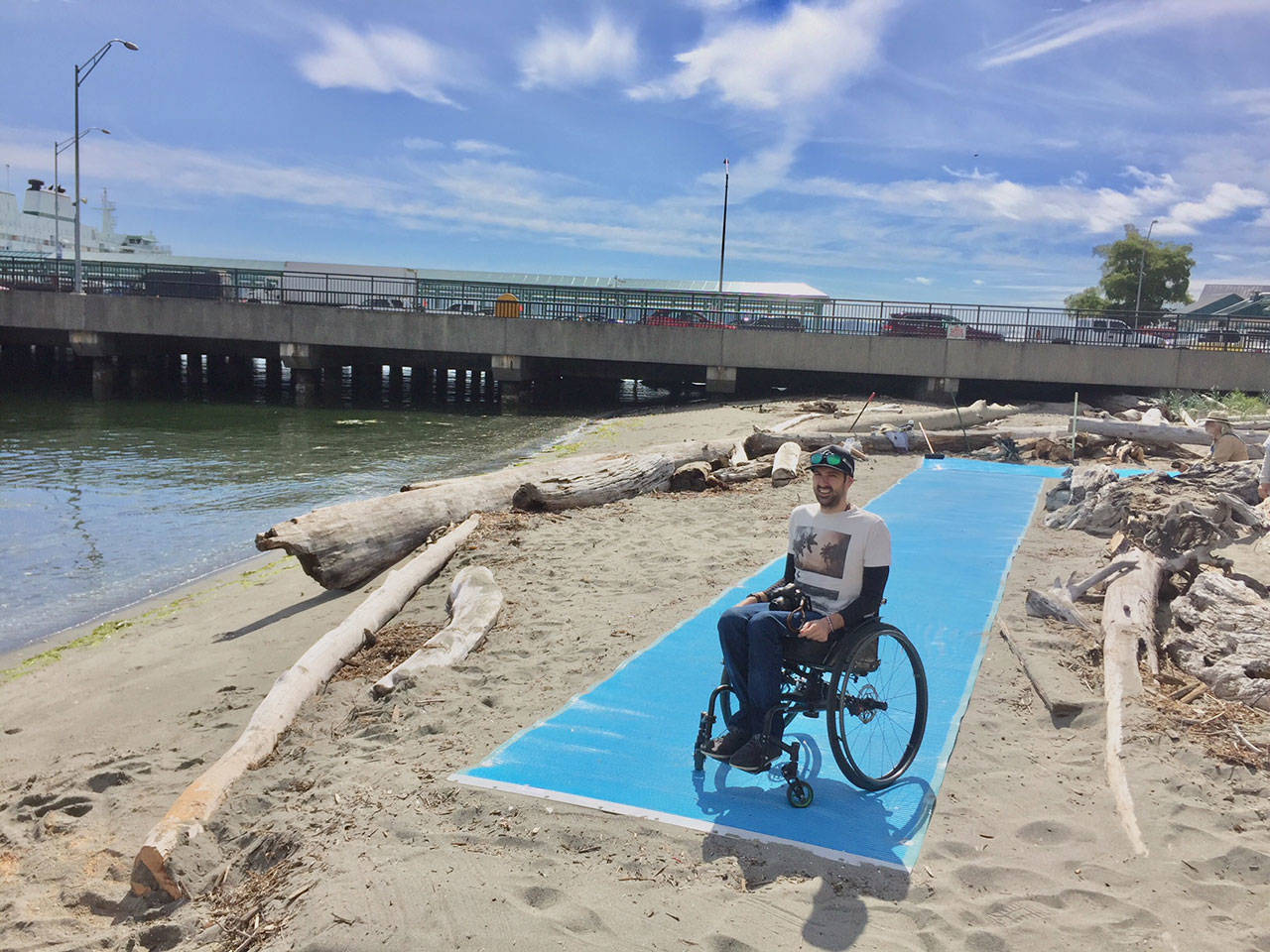 Contributed photo — Kyle Richardson, a Langley resident, poses for a picture at the end of a roll-out mat at Clinton Beach Park. It’s one of several at the park that were installed as a part of a universal access project.