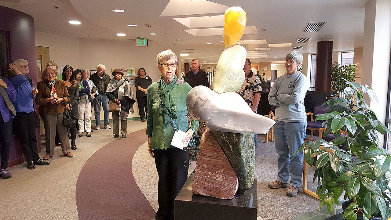 WhidbeyHealth photo — Joann Peterson examines Sue Taves’ sculpture “Hearts” after it is unveiled in the lobby of the WhidbeyHealth Medical Center.