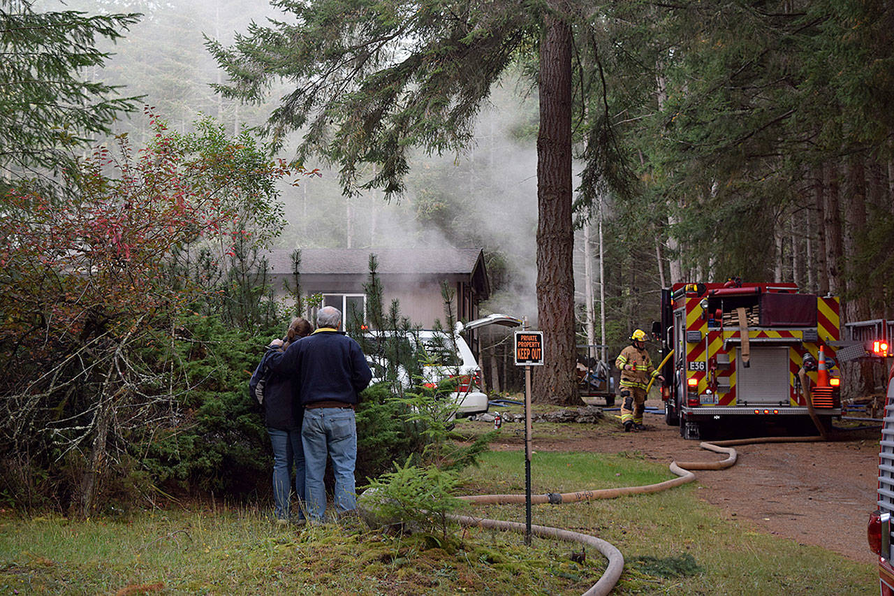 Kyle Jensen / The Record &mdash; The homeowner&rsquo;s parents watch as a fire blazes in the downstairs crawlspace on Wednesday morning.