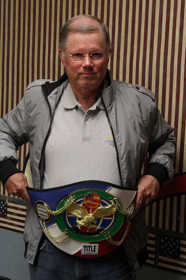 Chuck Yursina shows off the wrestler-style belt he won at last month’s Long Beach Invitational Cribbage Tournament.