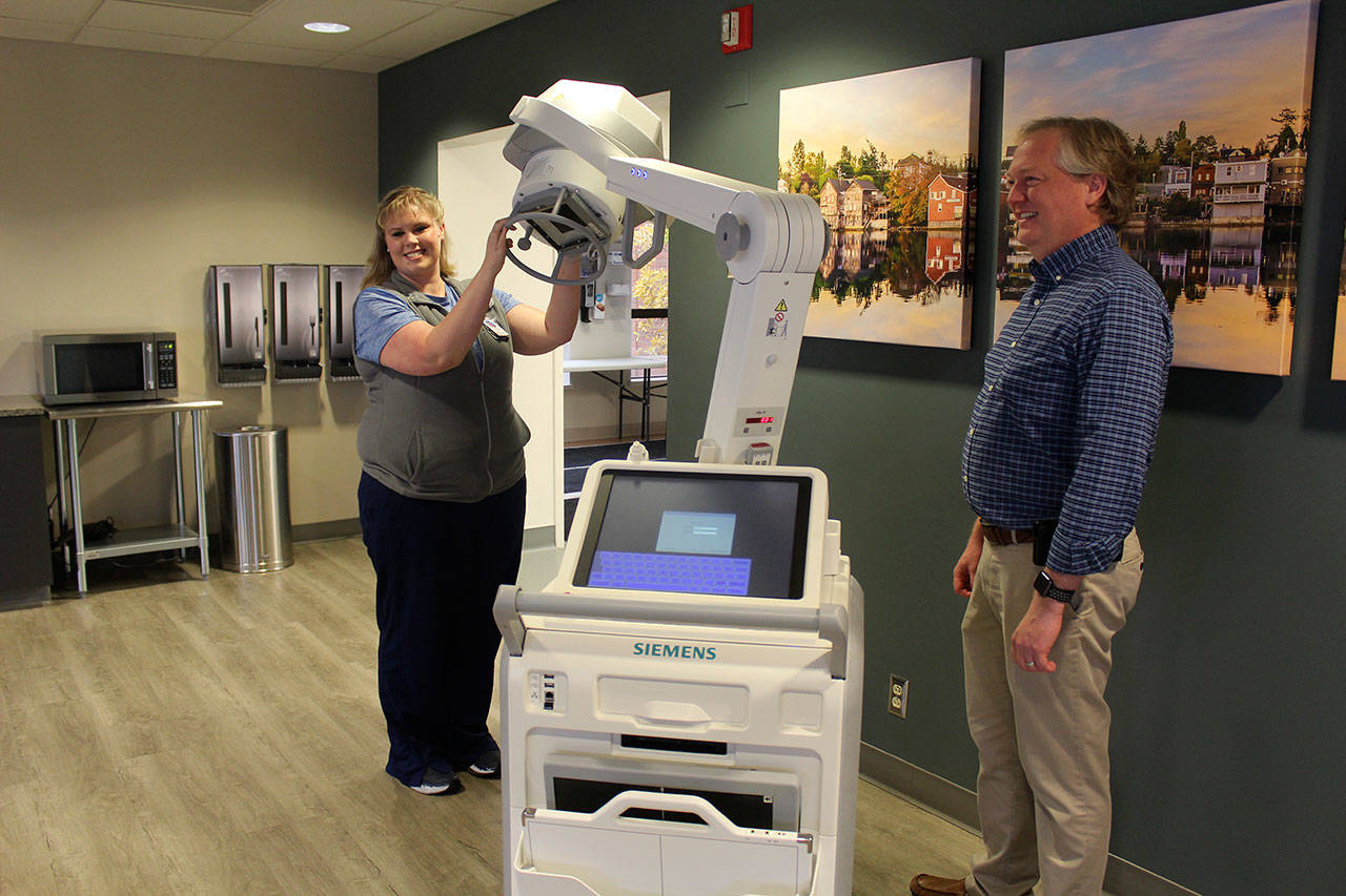 Patricia Guthrie / Whidbey News Group                                Lead imaging technologist Amanda Garlock shows off a new mobile x-ray machine following a WhidbeyHealth board meeting. The public health system announced Monday its replacing all its diagnostic imaging machines under a new agreement with Siemens Healthineers.