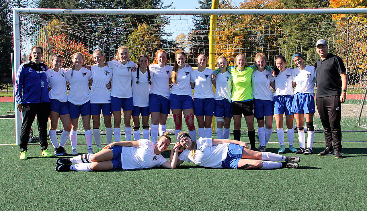 Bob Murnane photo  South Whidbeys girls soccer team poses for a photo. Foreground, from left to right: Mikayla Hezel, Maddy Drye. Second row, from left to right: Terry Swanson (head coach), Karyna Hezel, Emily Vanberg, Lila McCleary, Julian Larson-Wickman, Alison Papritz, Sophia Olsson, Samantha Ollis, Ashley Ricketts, Mallory Drye, Nicole Helseth, Raven Winter, Kelly Murnane, Lily Farnham and Ernie Merino (assistant coach).