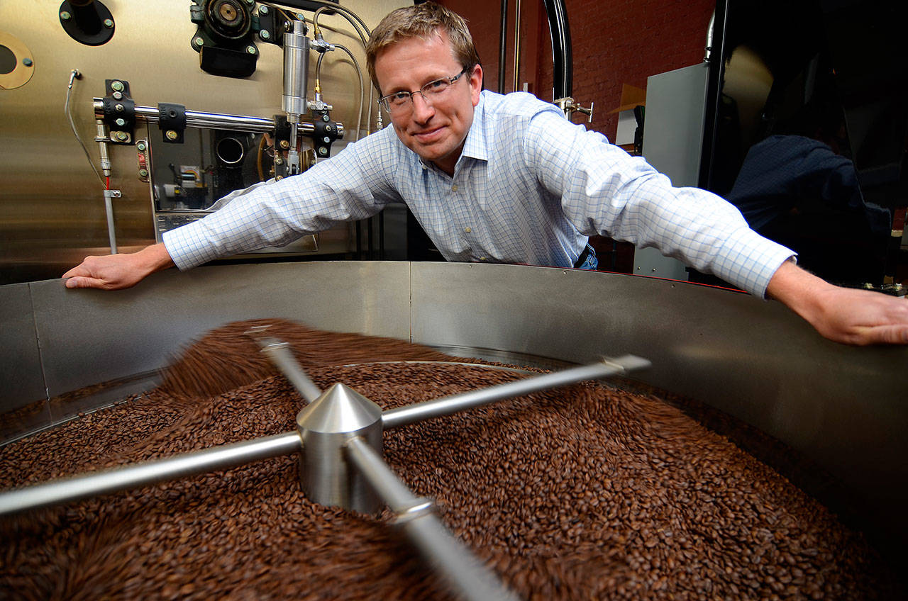 Record file — Whidbey Coffee owner Dan Ollis stands over a roaster in 2014.