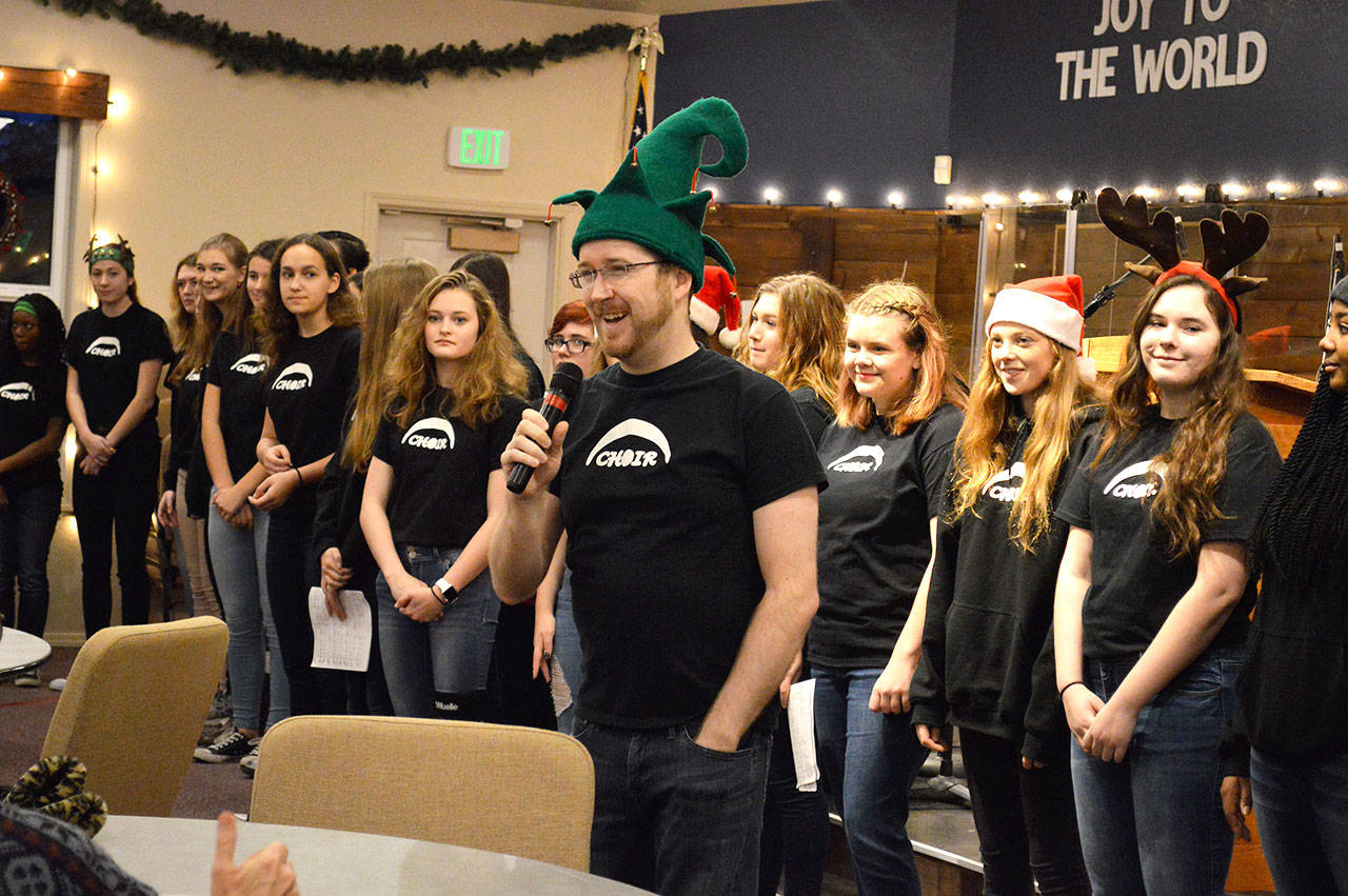 Darren McCoy, choir teacher at Oak Harbor High School, introduces his students before a performance at Family Bible Church on Friday morning. Photo by Laura Guido/Whidbey News-Times