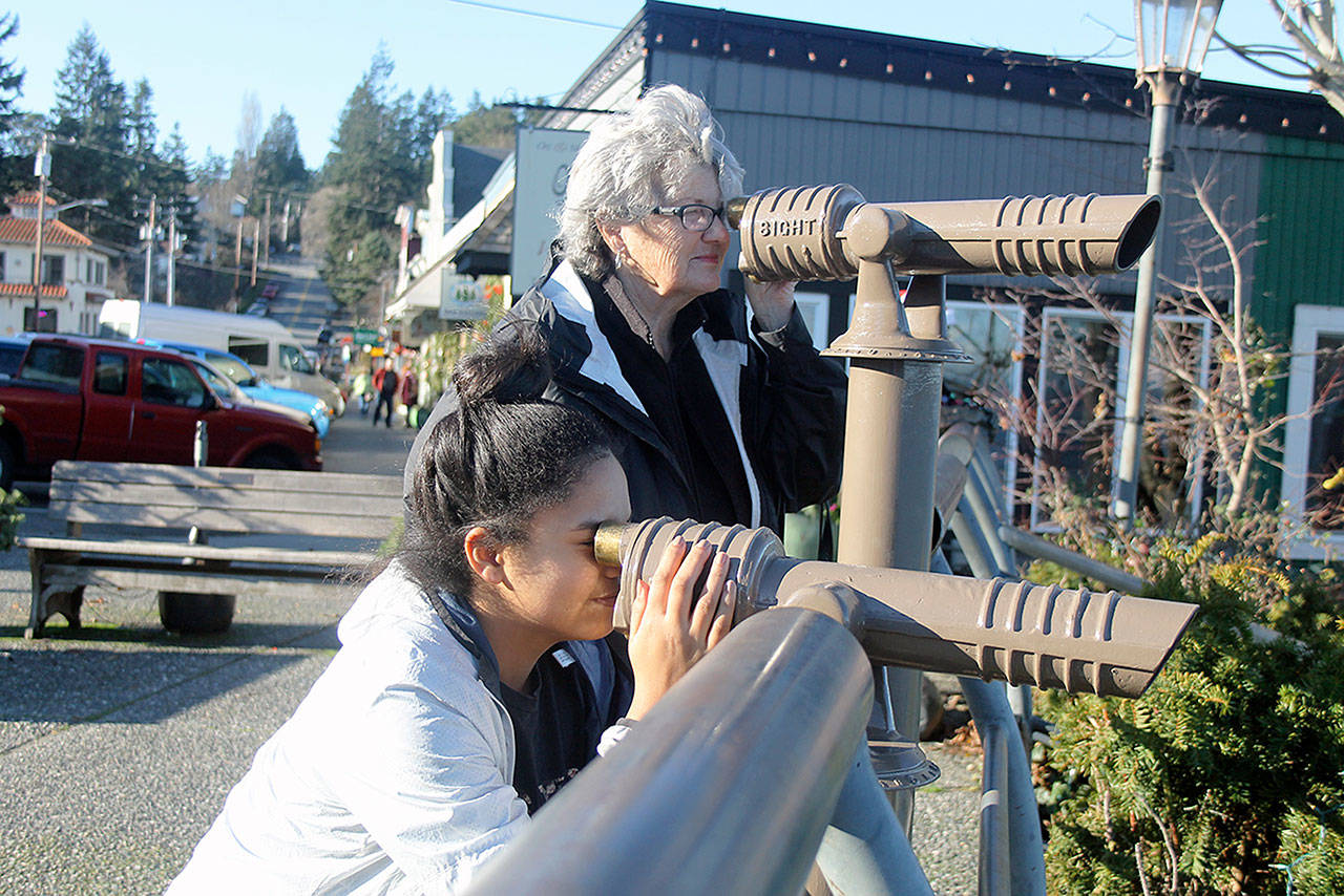 Evan Thompson / The Record — West Seattle residents DeeDee Coghill and Alexis Berridge-Green peer out across Saratoga Passage on Wednesday at Boy and Dog Park in Langley using new telescopes recently installed by the city.
