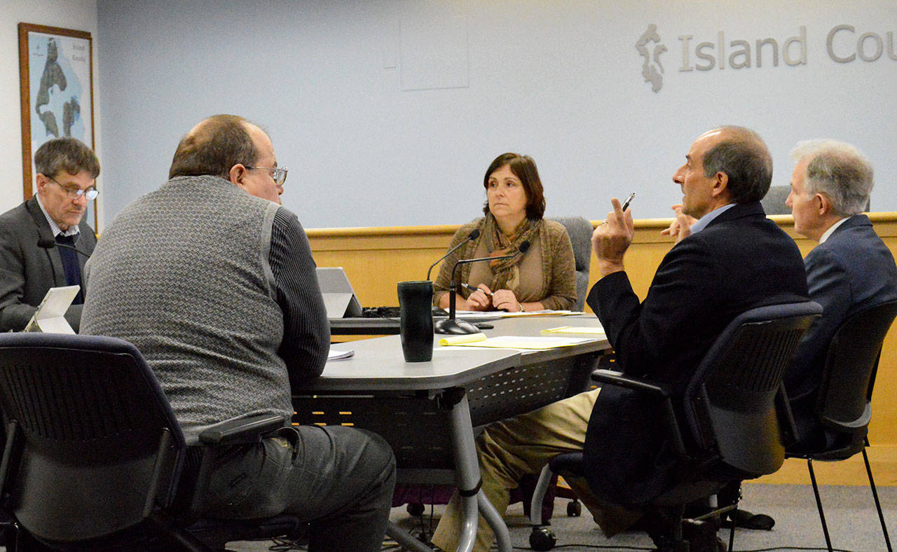 Laura Guido / Whidbey News Group                                County Prosecutor Greg Banks, center, attorney Lee Pence and County Commisioner Helen Price Johnson sit around the work session table Wednesday. Tensions hit a boiling point during the meeting that included yelling and name-calling.