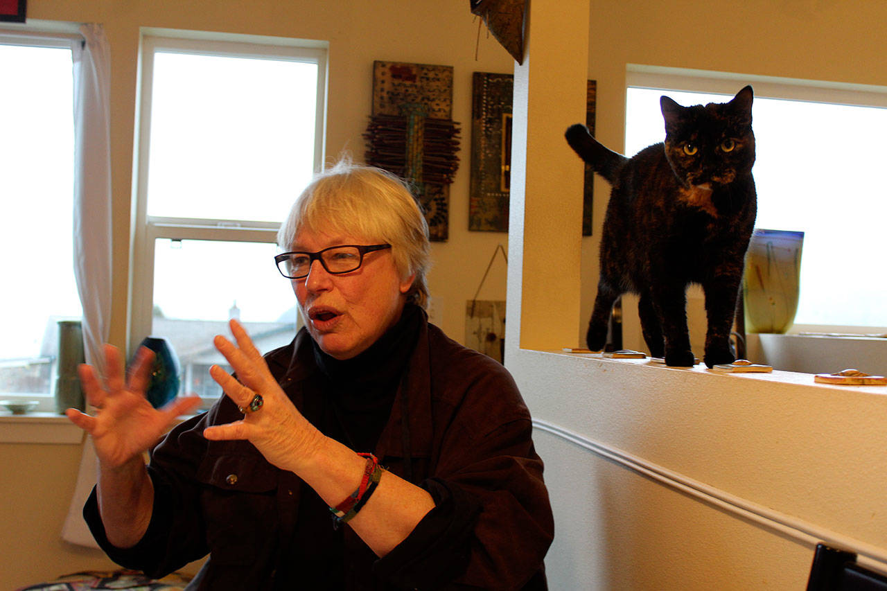 Susan Jensen at home with with cat, Maggie. Well-known on Whidbey for her pet caricatures, Jensen recently wrote two children’s books dealing with the weighty issues of alcoholism and global warming. Photo by Patricia Guthrie/Whidbey News-Times