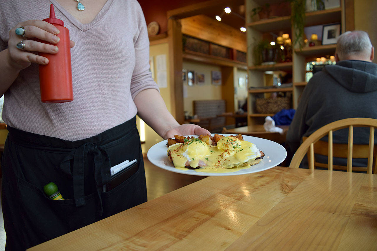 Kyle Jensen / The Record — A server brings out eggs benedict during lunch on Monday.