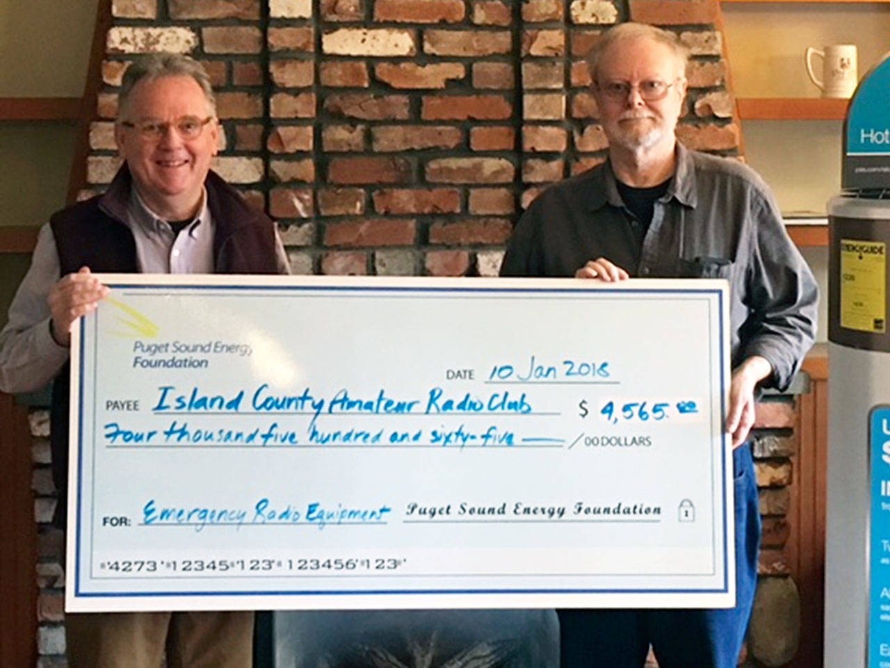 Contributed photo — Walt Blackford (left), Puget Sound Energy regional outreach manager, presented a grant of $4,565 from the Puget Sound Energy Foundation to John Acton of the Island County Amateur Radio Club (ICARC).
