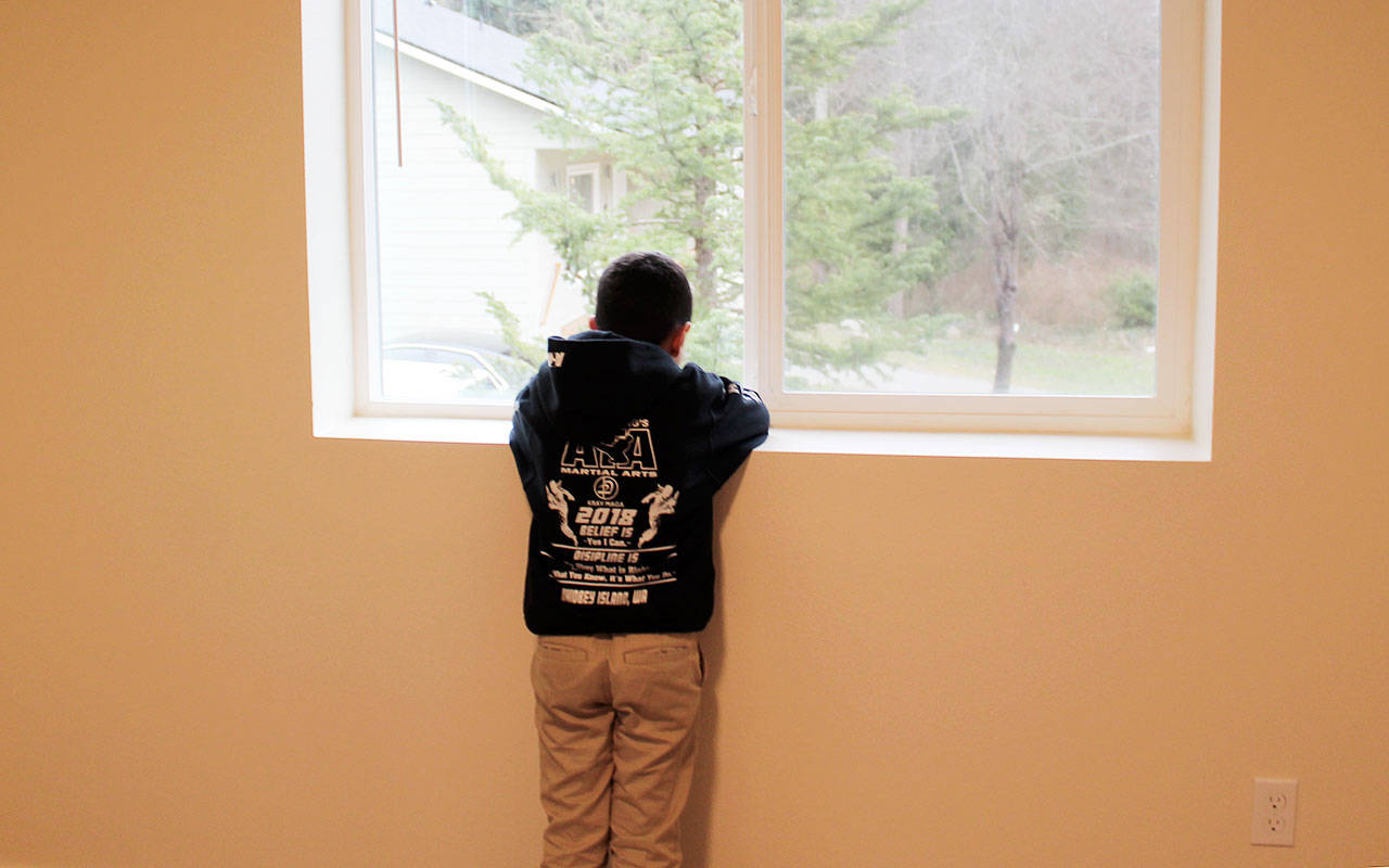 Knox Shannon, 8, looks out the window of his new bedroom in the house built by Habitat for Humanity. Island County is set to implement fee changes that would result in savings for the organization, and other developers, in the plan review stage of receiving building permits. Photo by Patricia Guthrie/ Whidbey News-Times