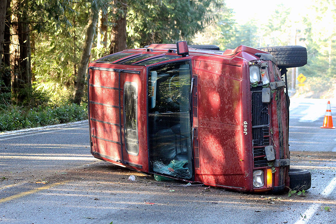 Evan Thompson / The Record  There was about one to two inches of snow accumulation on Feb. 21-22. Though not all areas of South Whidbey had visible snow late in the afternoon on Thursday, ice was still a problem. Rusty Floyd rolled his 1990 Jeep Cherokee when his vehicle slid on on an icy patch next to the orange cone in the background. Floyd, a 37-year-old Clinton resident, was uninjured.